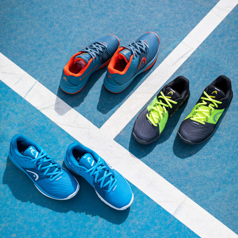 The collection of colours available of The Head Revolt Pro 4.0 Junior Tennis shoes on a tennis court