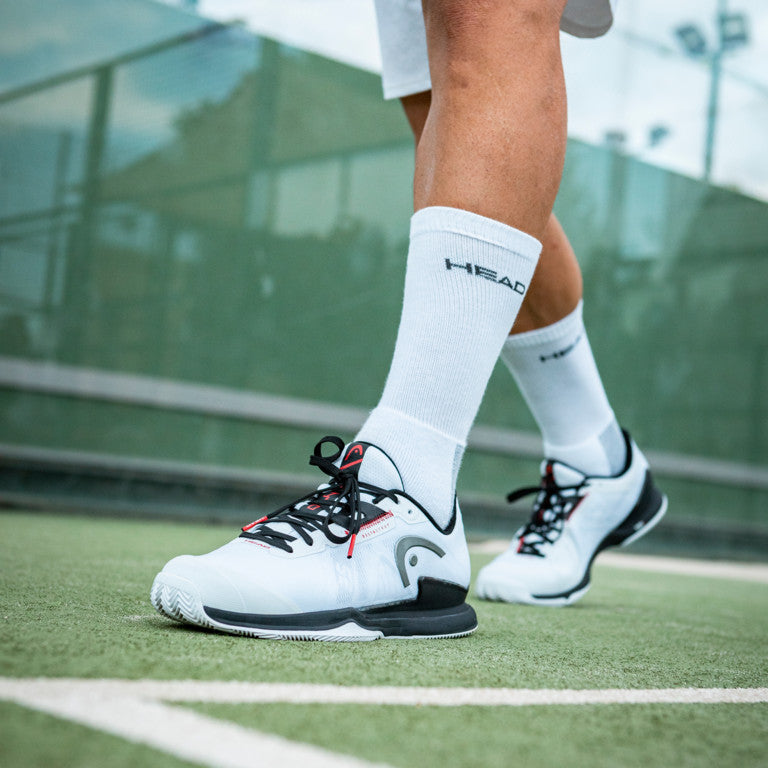 The Head Sprint Pro 3.5 Mens Clay & Padel Shoes in White/Black on a padel court available for sale at GSM Sports